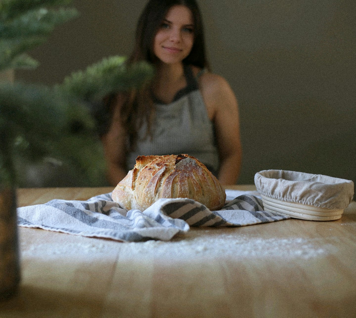 Pane a lievitazione naturale su un canovaccio accanto a un cestino.
